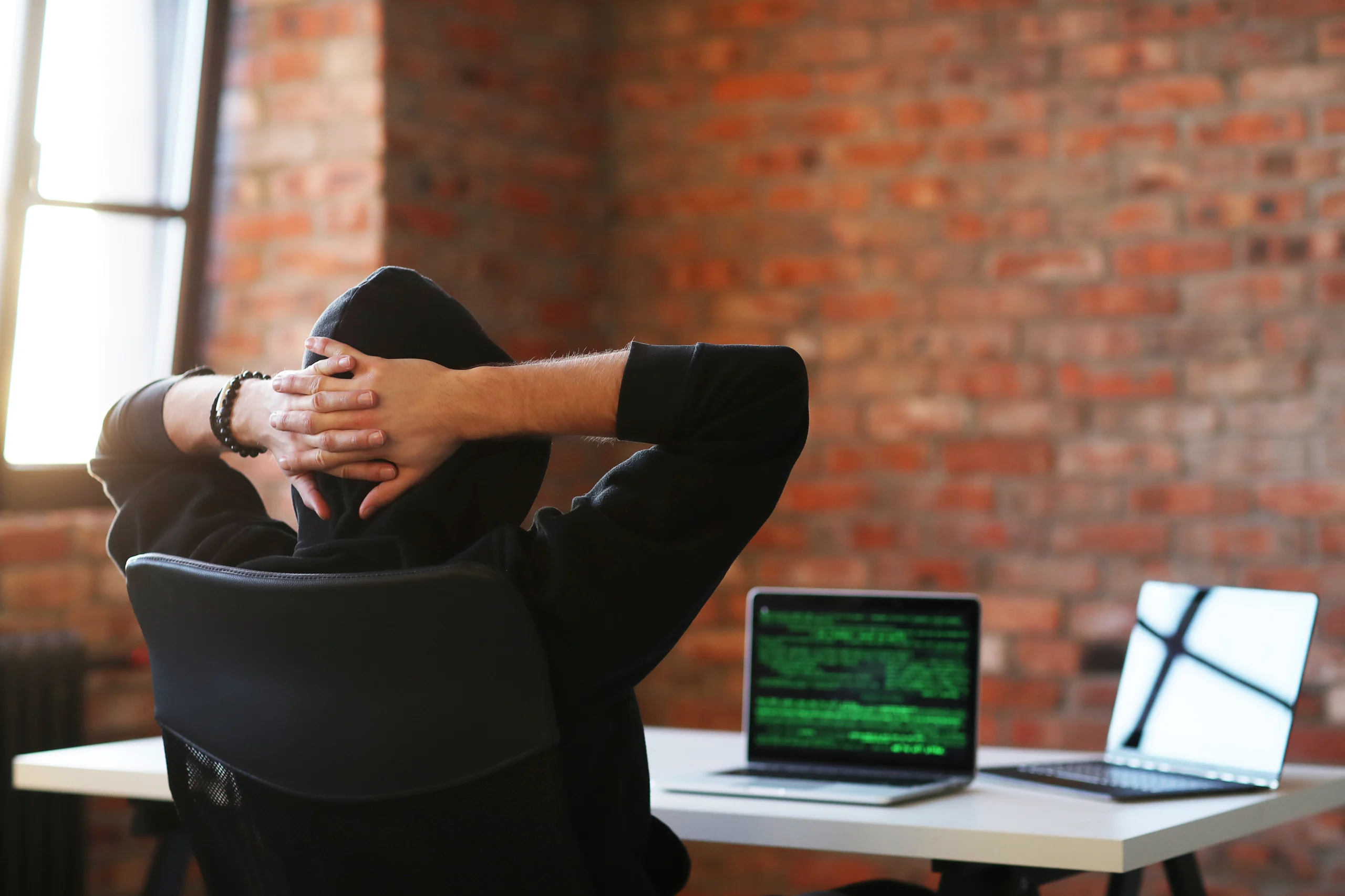 A men in hoodie and a laptop